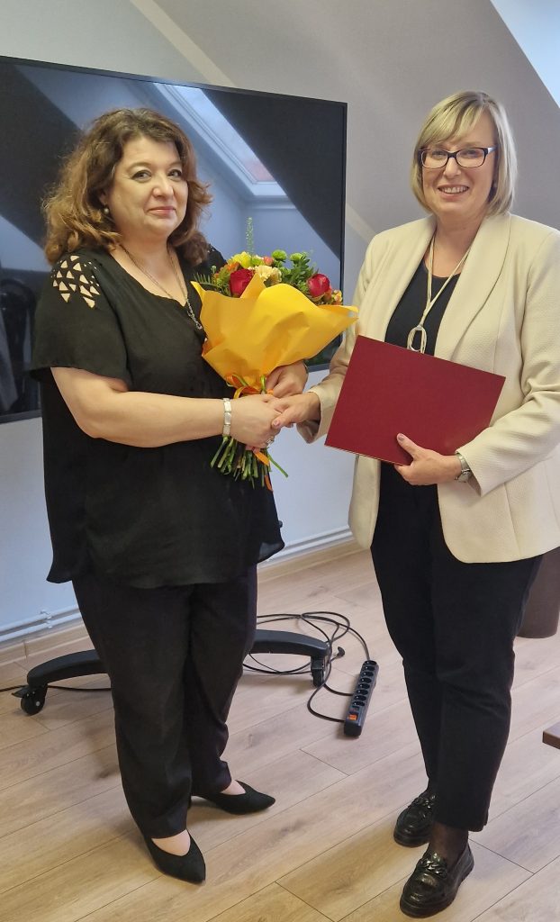 Zdjęcie przedstawiające wręczenie kwiatów mgr Joanny Woźniak z okazji 25-lecia pracy.