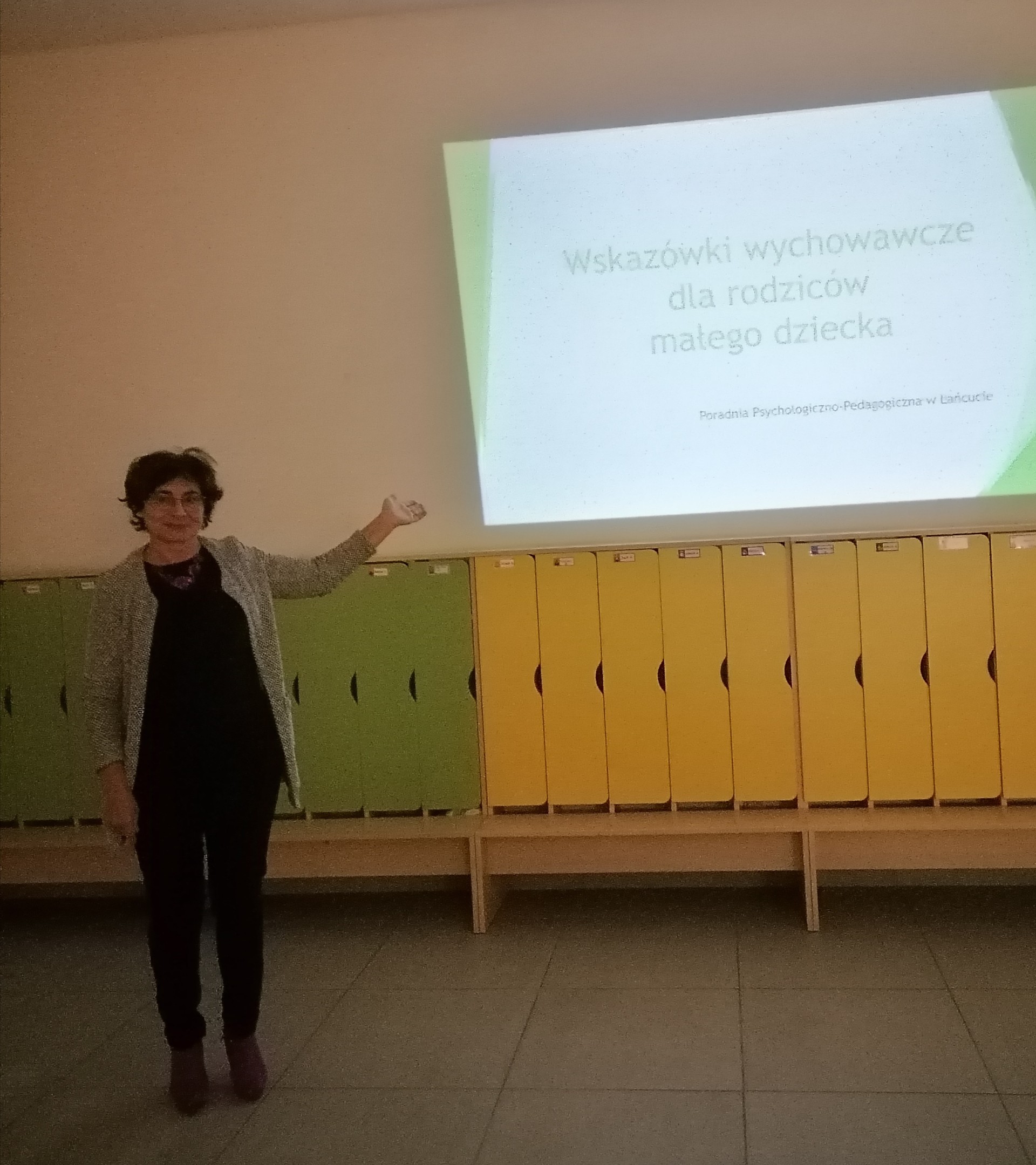 Zdjęcie przedstawiające mgr Magdalenę Krzywonos oraz slajd z prezentacji Wskazówki wychowawcze dla rodziców małego dziecka